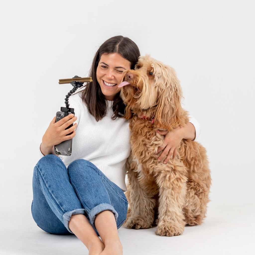 Woman with dog using a dental stick selfie-stick 