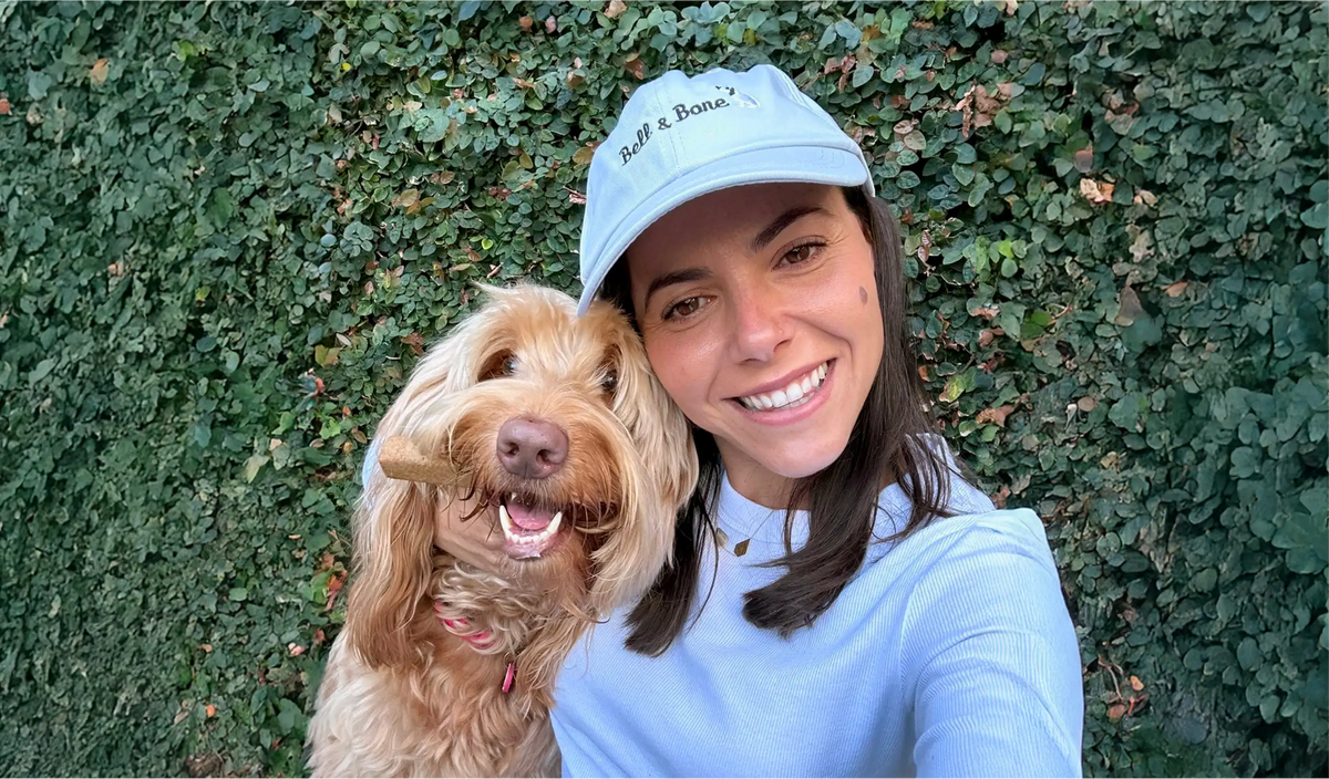 Bell & Bone founder Arianne with her dog Louie and a Dental Stick, daily dog dental care tips